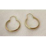 A small pair of gold hoop style earrings.