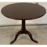 A Georgian mahogany tip top table on tripod footed pedestal base.