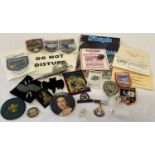 A small collection of vintage pin badges, cloth patches and business cards.