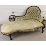 A Victorian walnut framed chaise lounge with green damask style upholstery and button back detail.