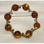 A modern design silver and amber brooch.