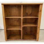 A vintage pine storage unit/bookcase with 4 shelves at varying heights.
