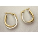 A pair of 9ct white and yellow gold intertwined hoop style earrings.