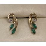 A pair of 9ct gold emerald and diamond set floral design earrings.