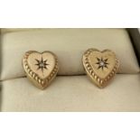 A pair of 22ct gold heart shaped earrings each set with a small diamond.