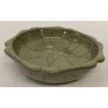 A Chinese green crackle glaze stoneware shallow bowl, raised on tripod feet.