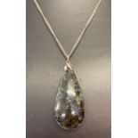 A teardrop design green and black jasper pendant on an 18" silver curb chain.