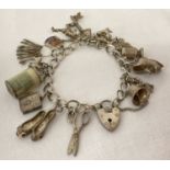 A vintage silver charm bracelet with padlock clasp, safety chain and 15 charms.