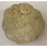 A Chinese carved jade roundel with figural detail, carving to both sides.