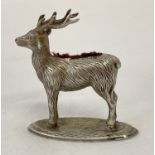 A novelty silver stag shaped pin cushion with worn red velvet cushion.