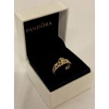 A boxed rose gold on silver tiara ring by Pandora. Set with a small round cut cubic zirconia stone.