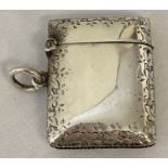 A Victorian silver vesta case with engraved floral detail to outer rim.