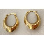 A pair of 9ct gold oval shaped hoop style earrings. Posts marked 9ct.