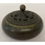 A Chinese bronze lidded censer of bulbous form with pierced design lid and spherical finial.