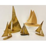 5 sailing boat figurines in varying sizes made from wood and brass.