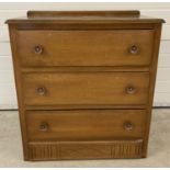 A vintage wooden 3 drawer chest of drawers with flower design metal handles.