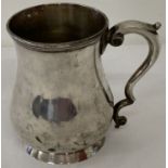 A hallmarked silver tankard with decoratively shaped handle.