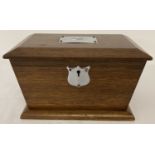 A vintage wooden sarcophagus shaped tea caddy with metal escutcheon & plate to lid.