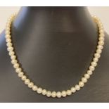 A 15" peach lustre freshwater pearl necklace with decorative white metal T bar clasp.