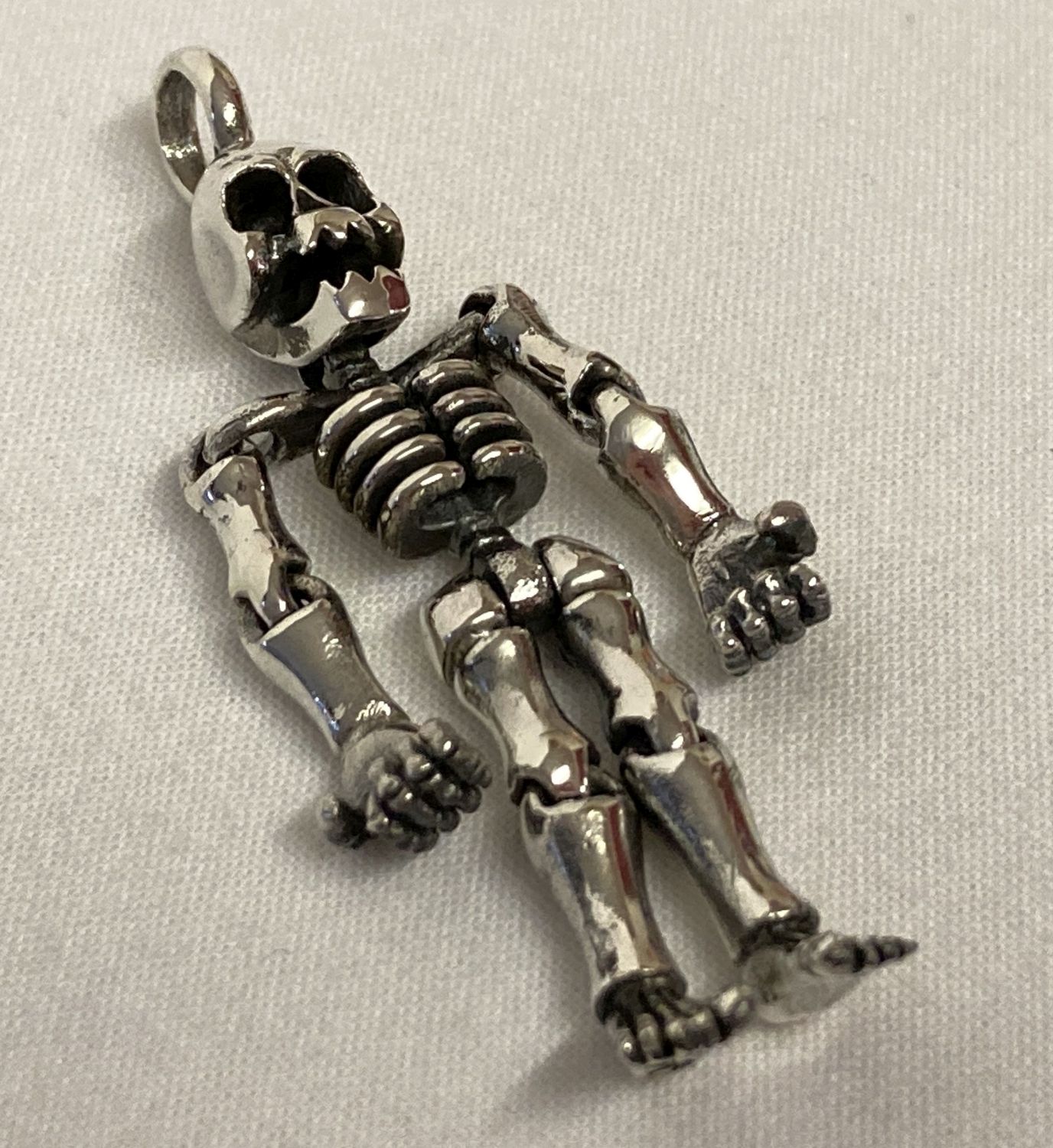 A 925 silver pendant in the form of an articulated skeleton.