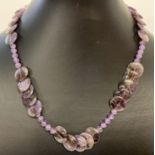 A 17" amethyst beaded necklace with circular and spherical shaped beads & a white metal T bar clasp.