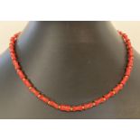 A small coral and gold tone bead necklace with screw clasp. Approx. 14".