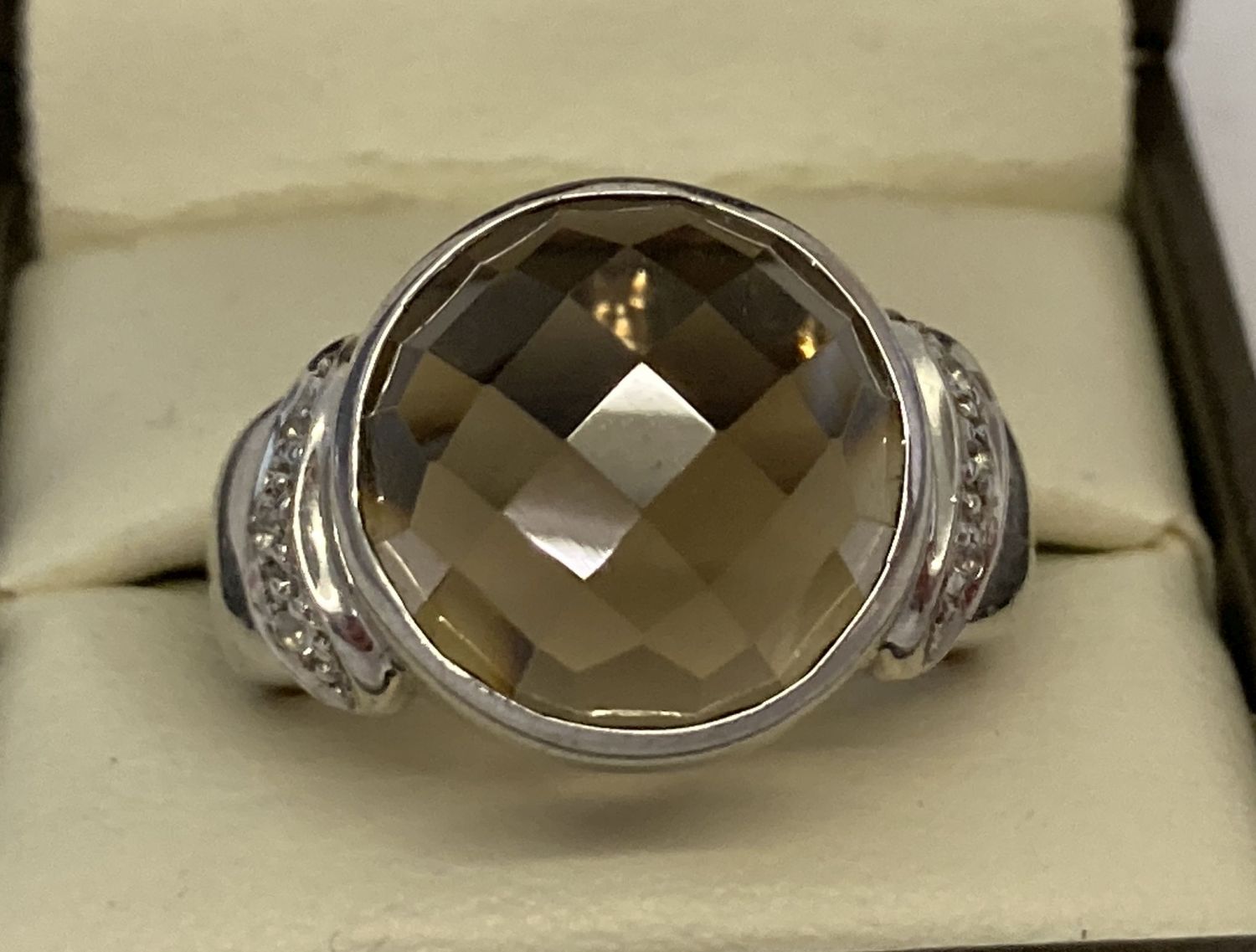 A silver cocktail ring set with checkerboard cut smoked quartz and diamonds.