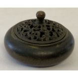 A small circular, Chinese bronze lidded censer with pierced work detail to lid.