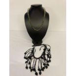 2 glass bead necklaces. A modern design black glass drop style statement necklace with leaf detail.