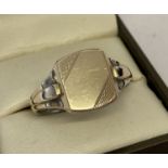 A men's vintage gold on silver square signet ring with engine turned detail and empty cartouche.