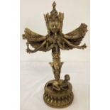 A Chinese bronze figurine of a 3 faced deity in gilt finish on a lotus flower shaped base.