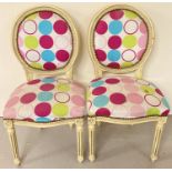 A pair of Louis XV style wooden framed balloon back style chairs, painted cream.