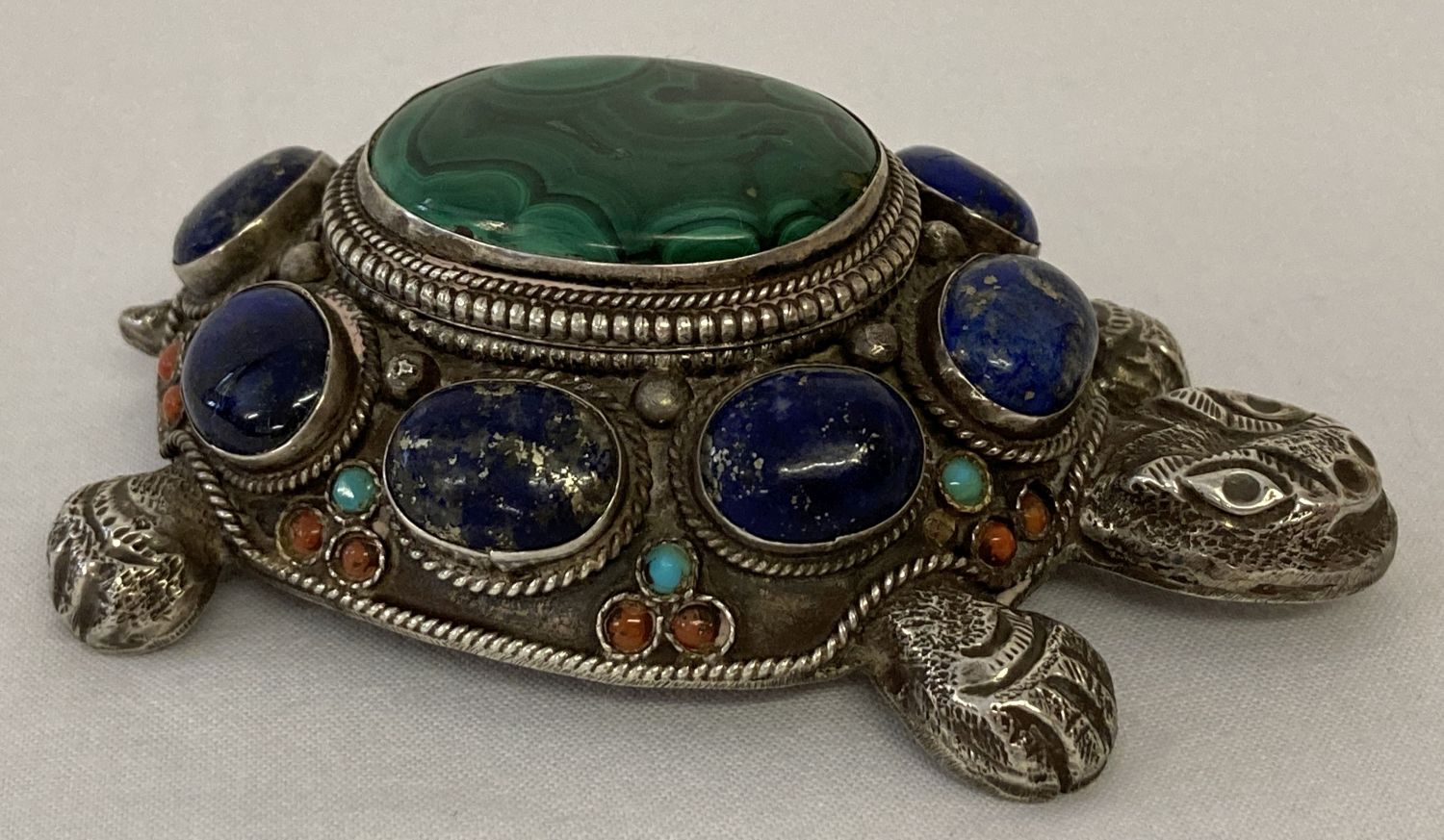 A decorative silver stone set trinket/pill box in the shape of a tortoise.