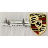 A wall mountable aluminium key hook with painted Porsche logo.