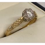 A vintage 18ct gold diamond solitaire ring with diamond cut pattern to shoulders.