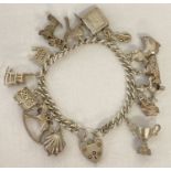 A vintage silver charm bracelet with padlock, safety chain and 14 silver and white metal charms.
