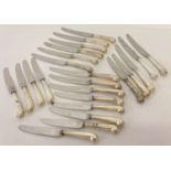 23 table knives with white metal pistol grip handles in two sizes.