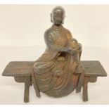 A bronze figurine of Buddha seated on a bench, with bronzed effect finish.