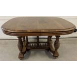 A Victorian oak extending dining table with 3 additional leaves.