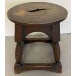 A dark wood Arts and Craft stool with curved cut out detail to top.