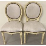 A pair of Louis XV style wooden framed balloon back style chairs, painted cream.