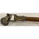 A reproduction wood and brass walking stick with swivel top telescope/compass handle.