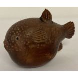 A small Japanese carved fruitwood snuff pot in the form of a pufferfish.