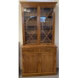 A modern reproduction satin wood veneer glass fronted bookcase.