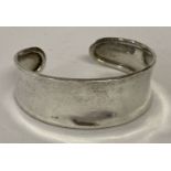 A modern design silver cuff bangle with silver marks to inside.