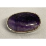 A small silver oval brooch set with Blue John stone.
