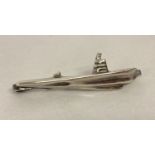 A white metal tie clip in the shape of a submarine.