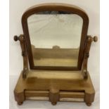 A Victorian dome topped swing mirror with 2 drawers to base. One bun foot missing.