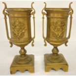 A pair of antique heavy brass urn style candlesticks with decorative panel to front.