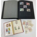 A black stamp album containing unfranked stamps from Laos together with a small stamp stock book